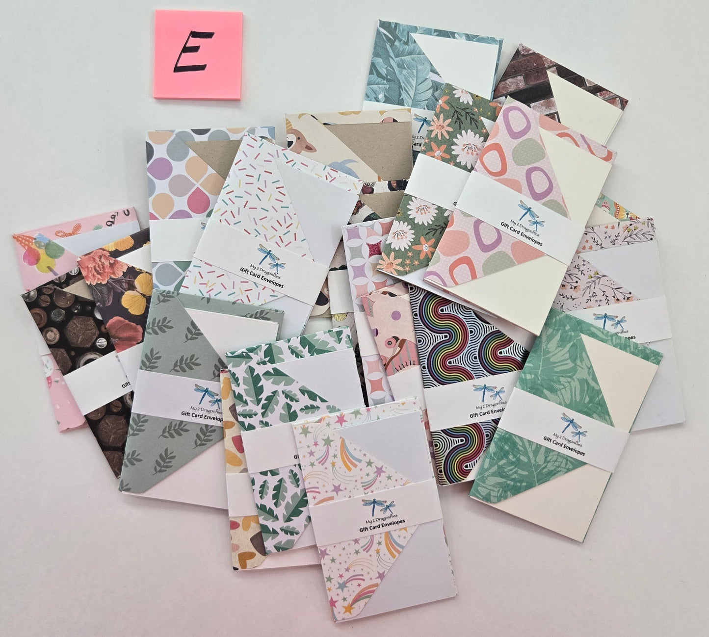 Collection of patterned cards on a light gray background with a pink sticky note labeled 'E'.