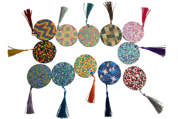 Colorful circular ornaments with tassels on a gray surface