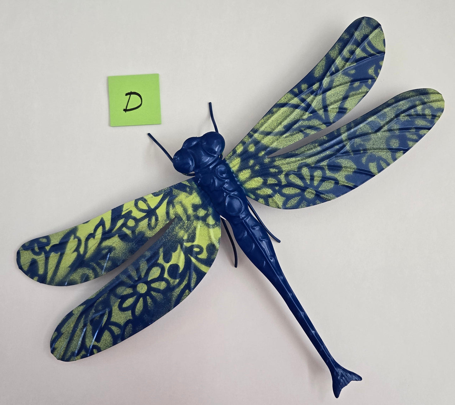 Decorative dragonfly wall art on a plain background