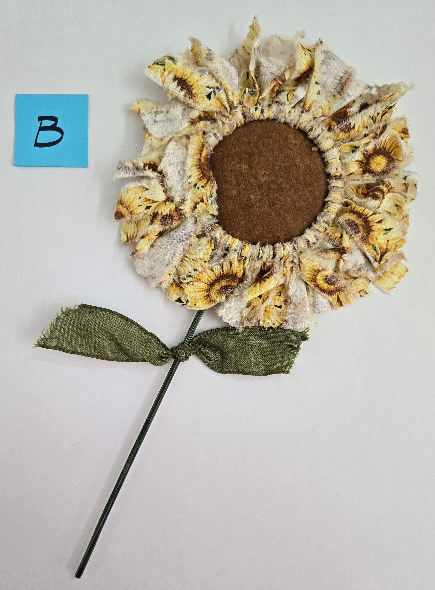 Decorative Sunflower plant pick on a light gray background.