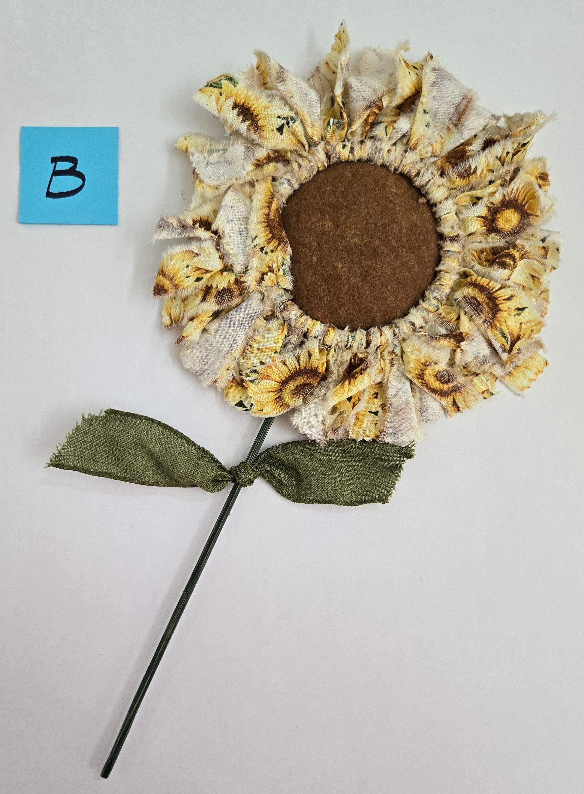 Decorative Sunflower plant pick on a light gray background.