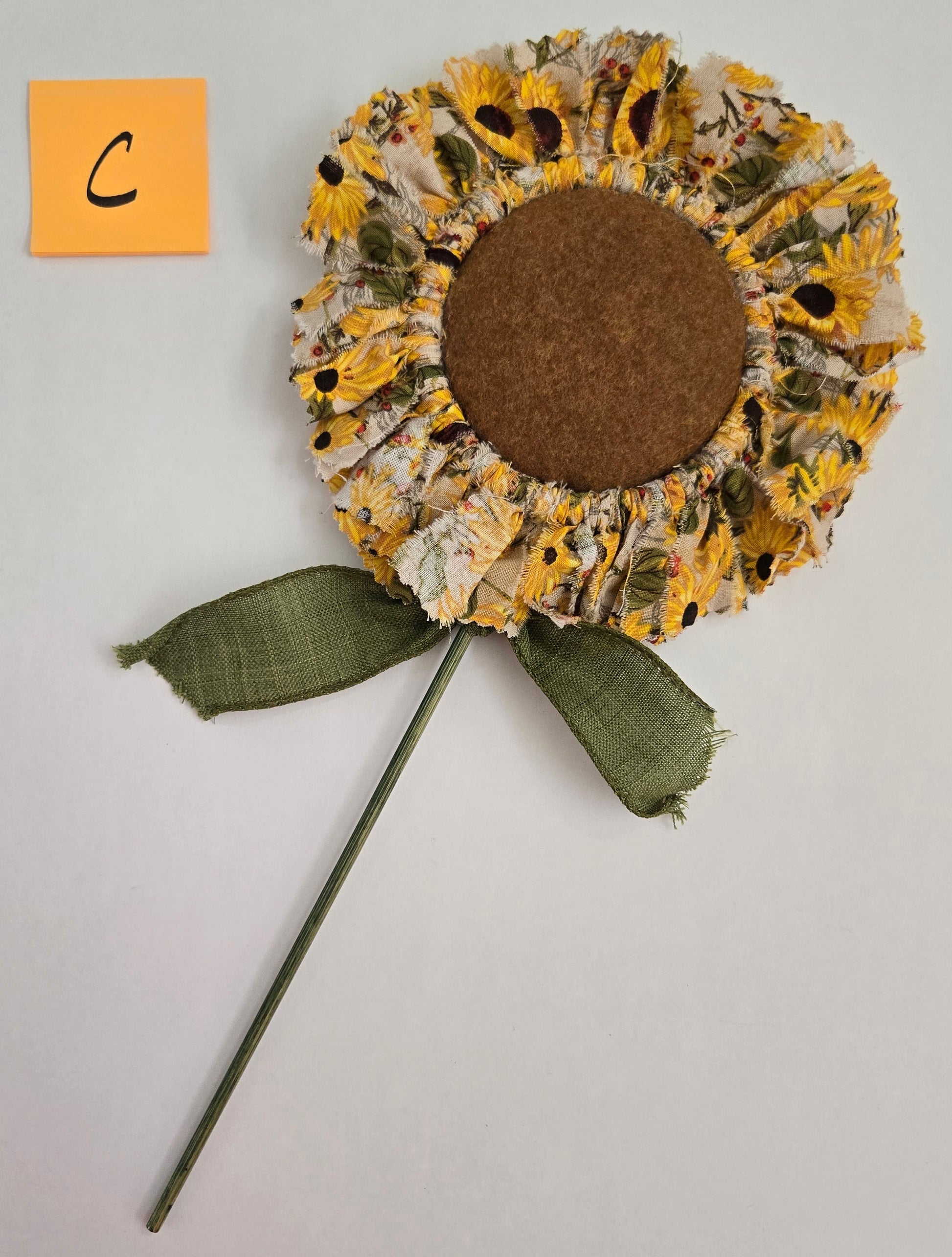 Decorative sunflower plant pick on a gray background