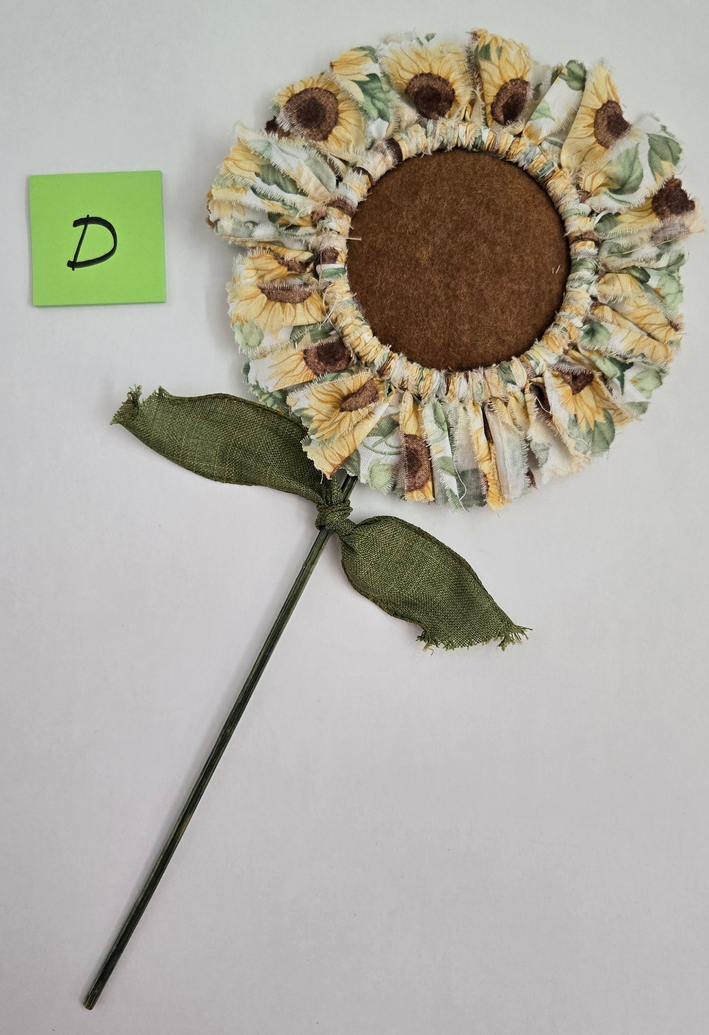 Decorative sunflower plant pick on a gray background
