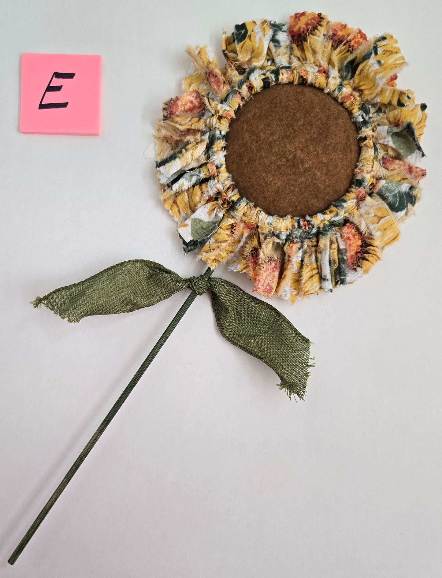 Decorative sunflower plant pick on a light gray background