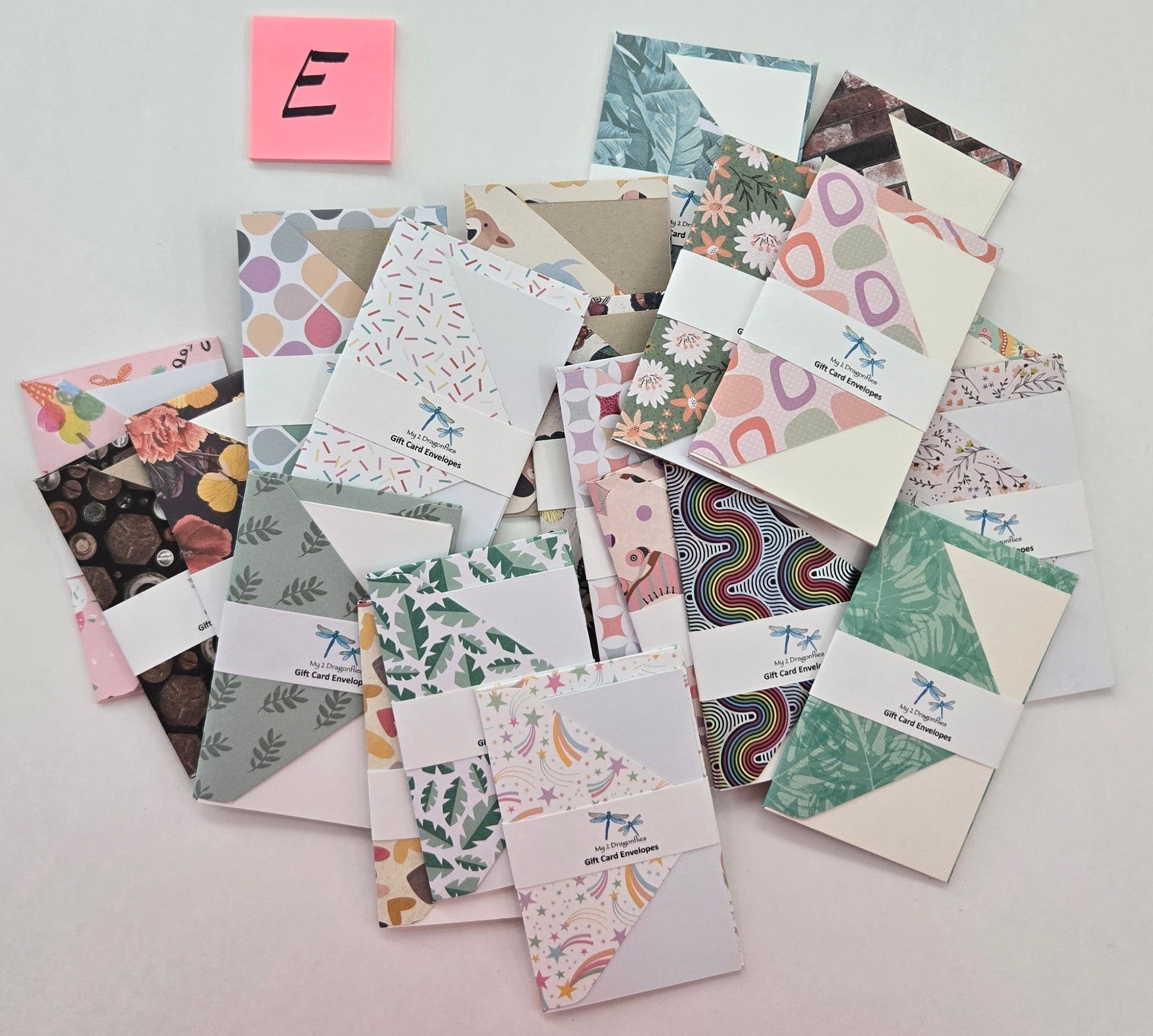 Collection of patterned cards on a light gray background with a pink sticky note labeled 'E'.