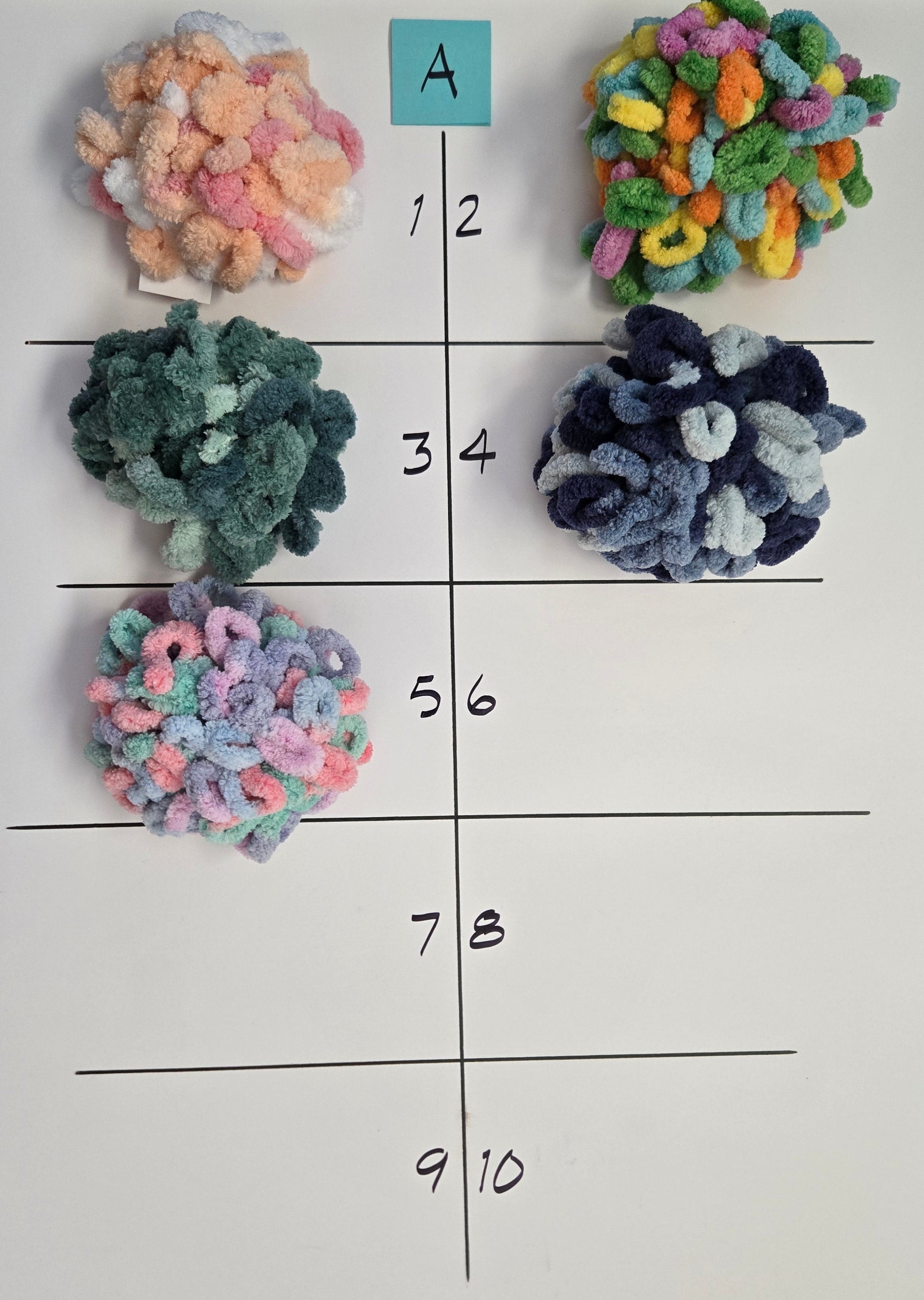 Colorful textured balls on a grid with labeled rows and columns on a white sheet of paper.