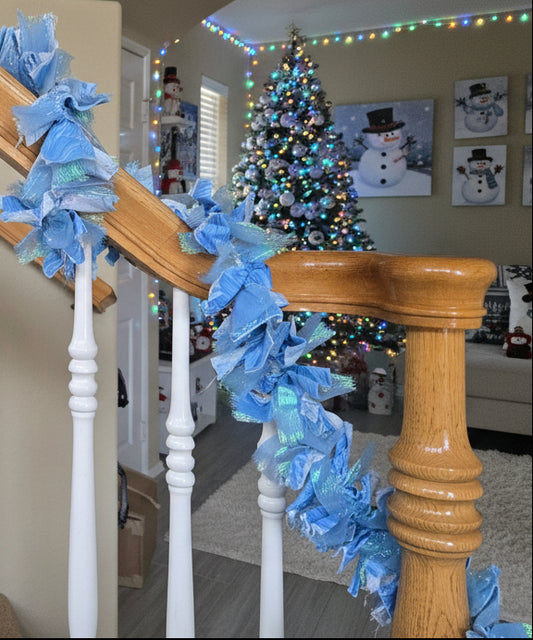 Decorative blue garland on a staircase railing in a home setting.