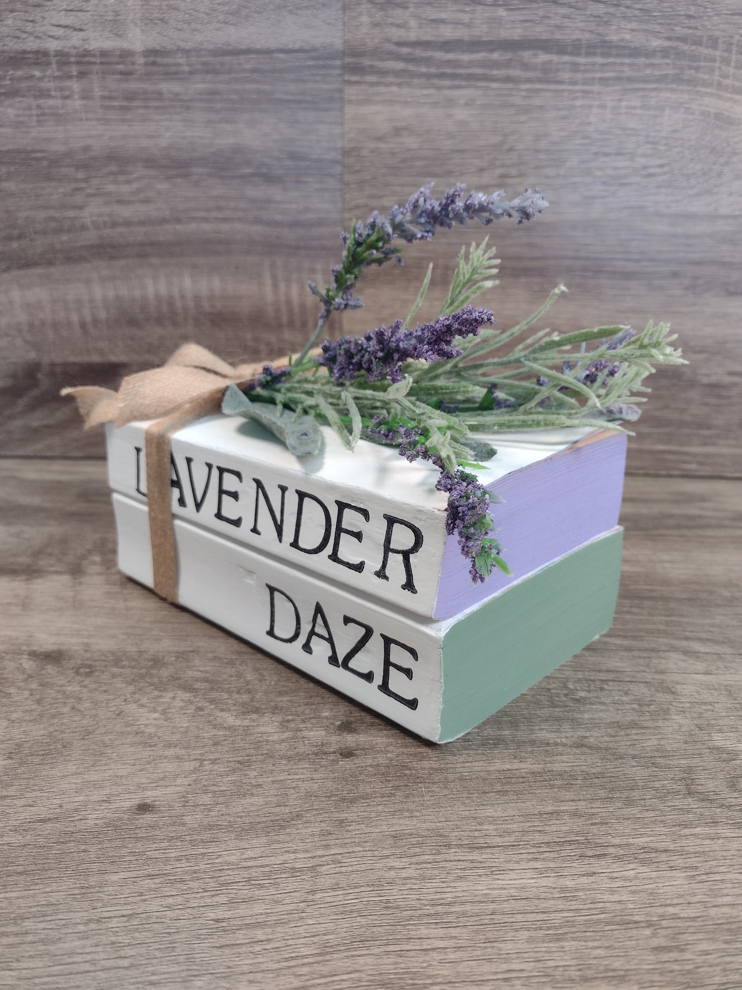 Decorative stacked books labeled 'Lavender Daze' with lavender flowers on a surface