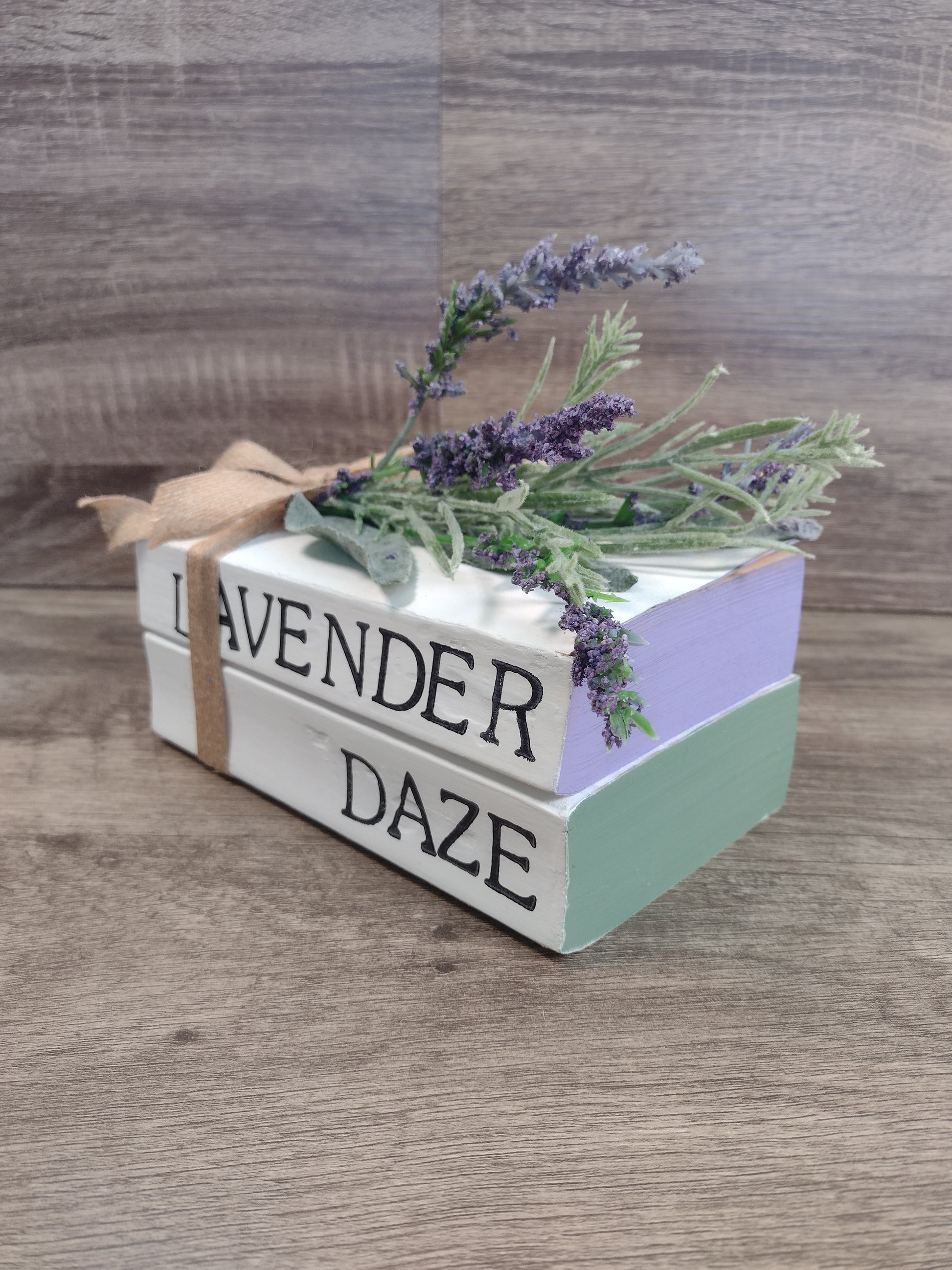Decorative stacked books labeled 'Lavender Daze' with lavender flowers on a surface