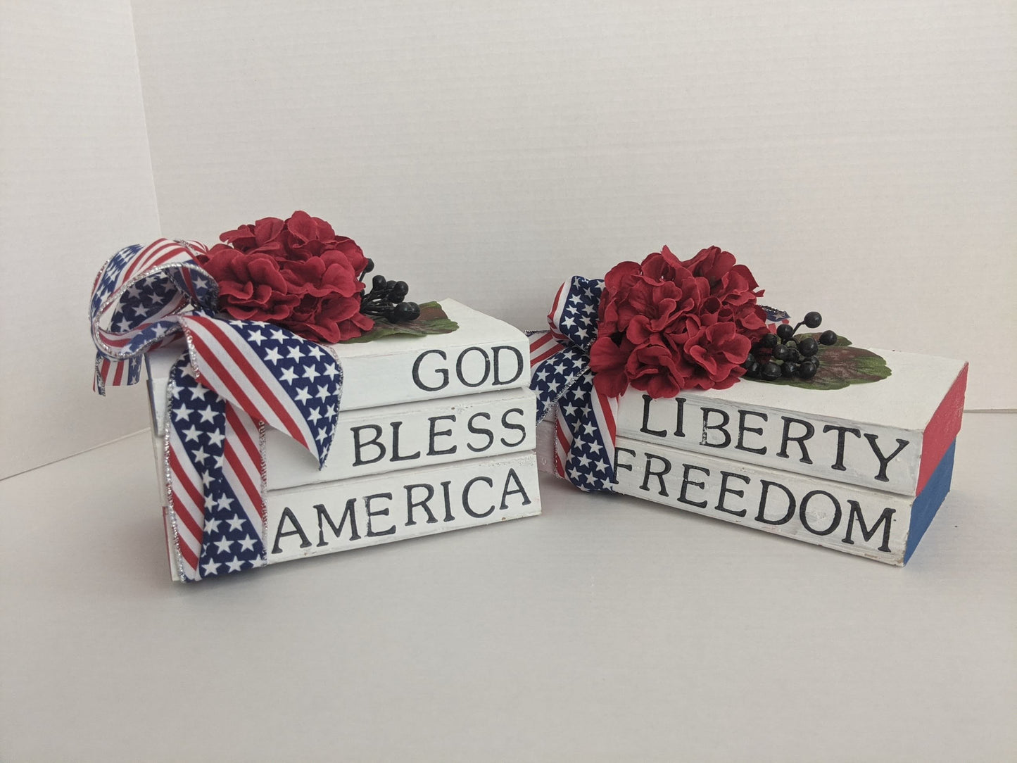 Two decorative stacked book sets with floral arrangements and American flag elements on a white background.